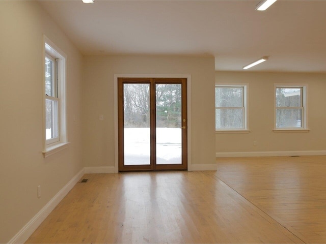 empty room featuring light wood finished floors and baseboards