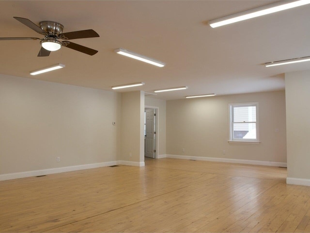 unfurnished room featuring baseboards, a ceiling fan, and light wood-style floors