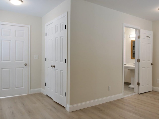 interior space featuring light wood-type flooring, a closet, and baseboards