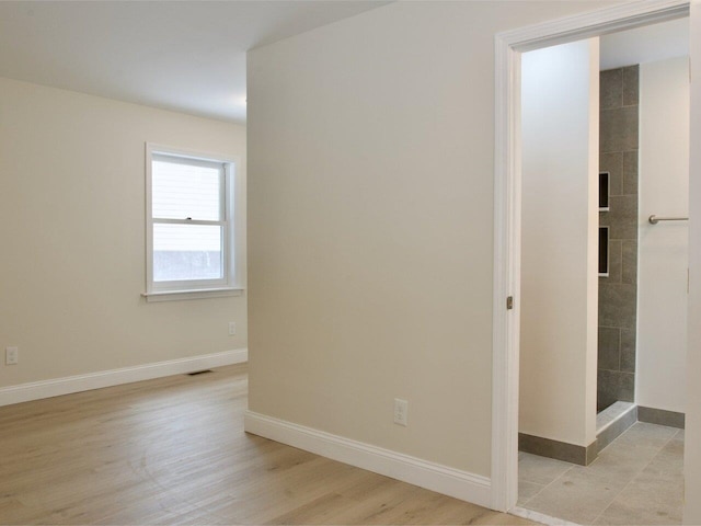 interior space featuring baseboards, visible vents, and light wood-style flooring