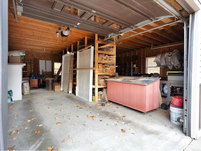 misc room with a garage and unfinished concrete flooring