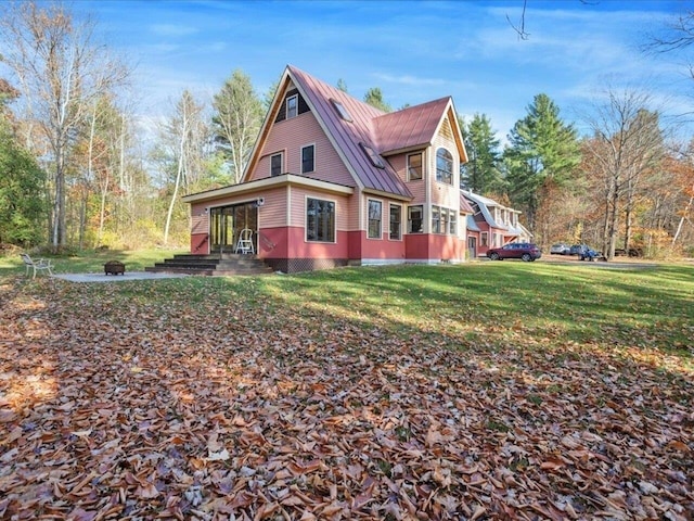 view of home's exterior featuring a fire pit, metal roof, a standing seam roof, and a lawn