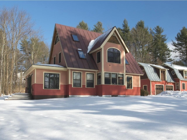 snow covered property with a standing seam roof and metal roof