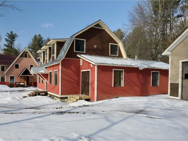 snow covered property with a gambrel roof