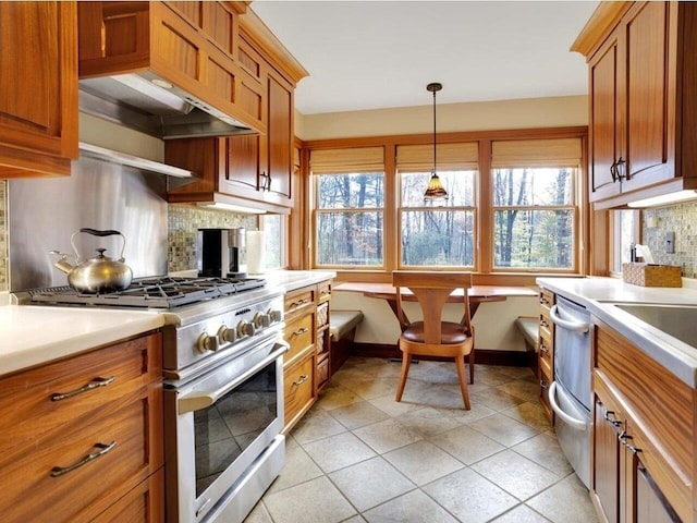 kitchen featuring brown cabinets, stainless steel range, tasteful backsplash, light countertops, and custom range hood