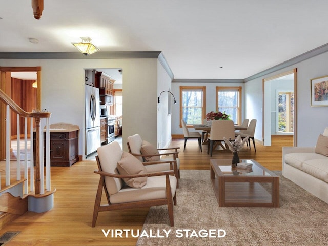 living area with ornamental molding, stairway, visible vents, and light wood-style floors