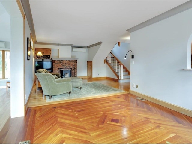 living area featuring stairs, ornamental molding, a wall mounted AC, and a fireplace