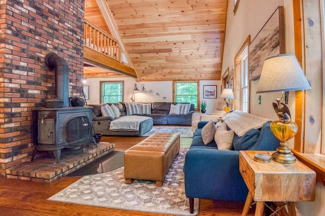 living area with high vaulted ceiling, wooden ceiling, wood finished floors, and a wood stove