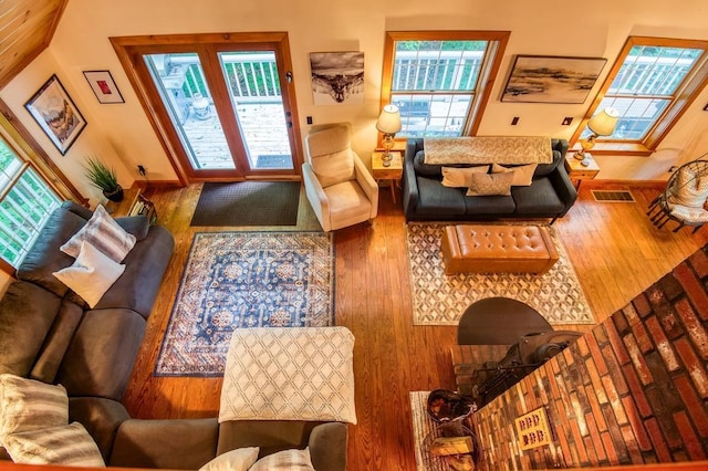 living area with wood-type flooring, visible vents, and baseboards