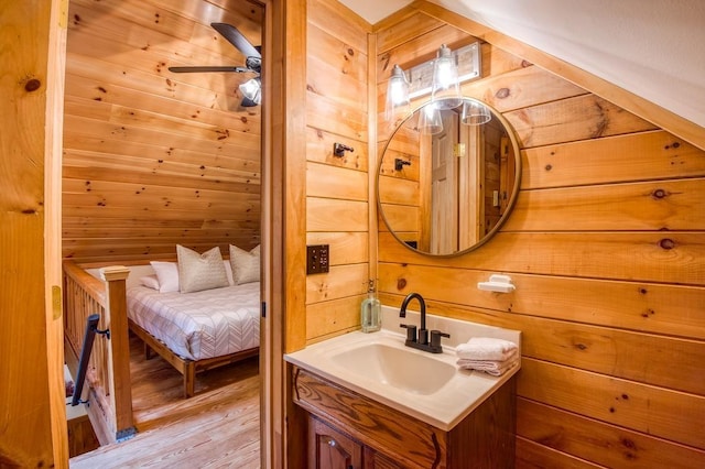 bathroom featuring wooden walls, wood finished floors, and vanity