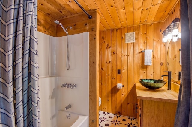 bathroom featuring wooden ceiling, wood walls, shower / bathtub combination with curtain, and vanity