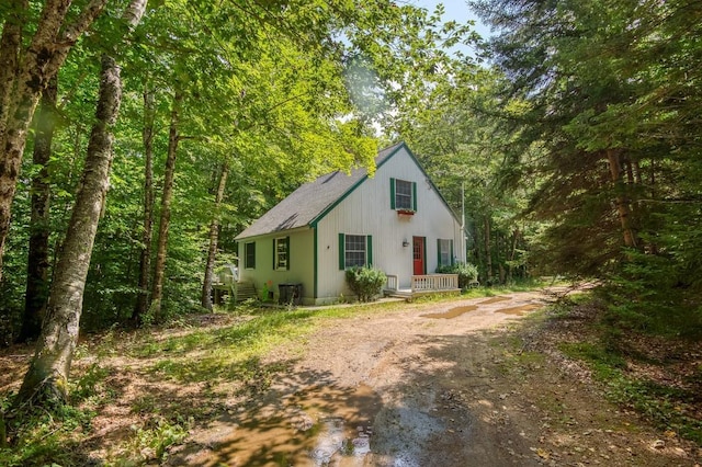 view of front of home with driveway and a view of trees