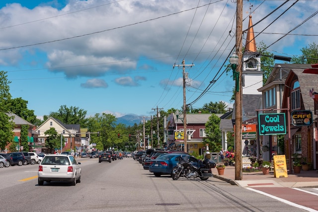 view of road with street lights, curbs, sidewalks, and a mountain view