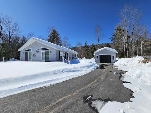 view of front of house with a garage, aphalt driveway, and an outdoor structure