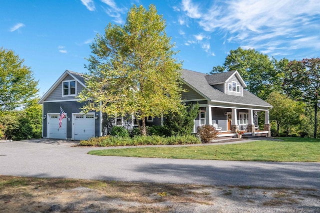 view of front of house featuring a porch, a front yard, driveway, and a garage