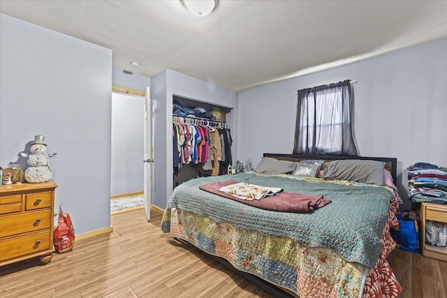 bedroom featuring a closet, wood finished floors, and baseboards