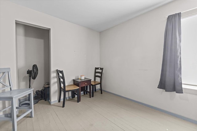 interior space featuring light wood-type flooring and baseboards