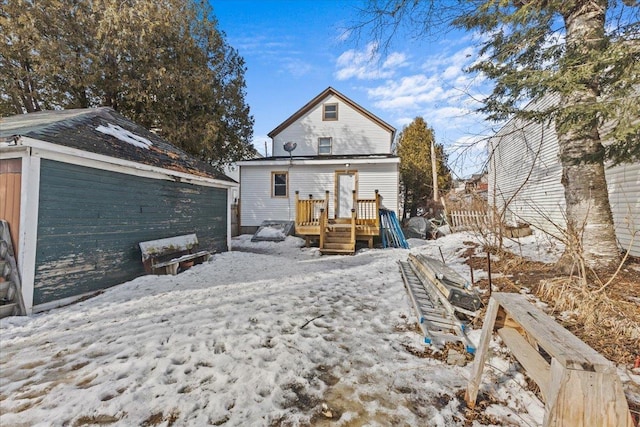 snow covered property featuring a deck and fence