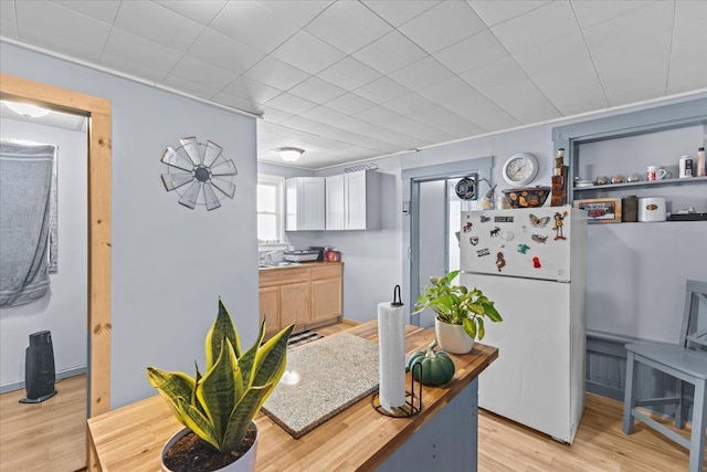 kitchen featuring freestanding refrigerator, light countertops, and light wood finished floors