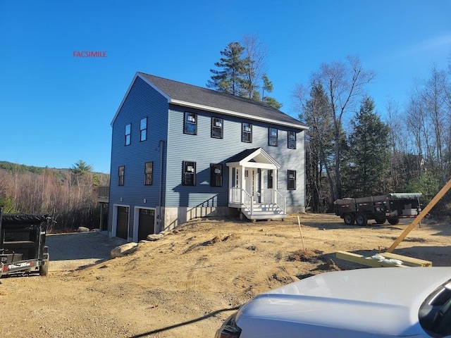 colonial inspired home with an attached garage and driveway