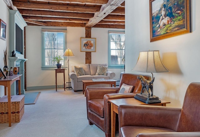 sitting room with carpet flooring, beam ceiling, and baseboards