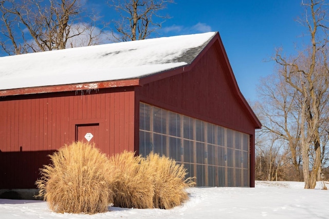 snow covered structure featuring a pole building and an outdoor structure