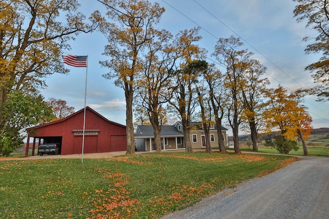 view of front of home with an outbuilding, driveway, and a front lawn