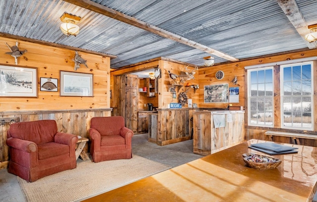 living area with concrete flooring and wood walls