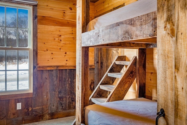 bedroom featuring wooden walls