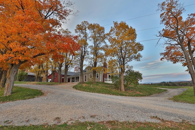 view of front of property with a front lawn and gravel driveway