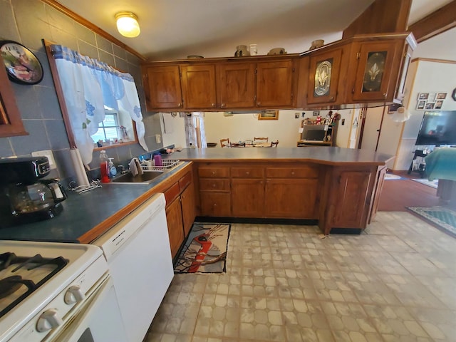 kitchen with dishwasher, a peninsula, a sink, and brown cabinets