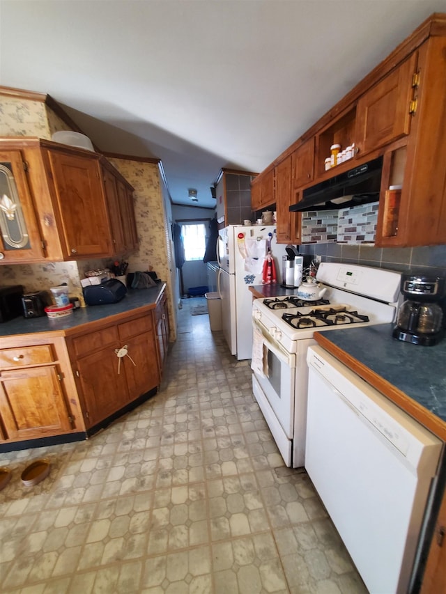 kitchen featuring white appliances, under cabinet range hood, brown cabinets, and light floors