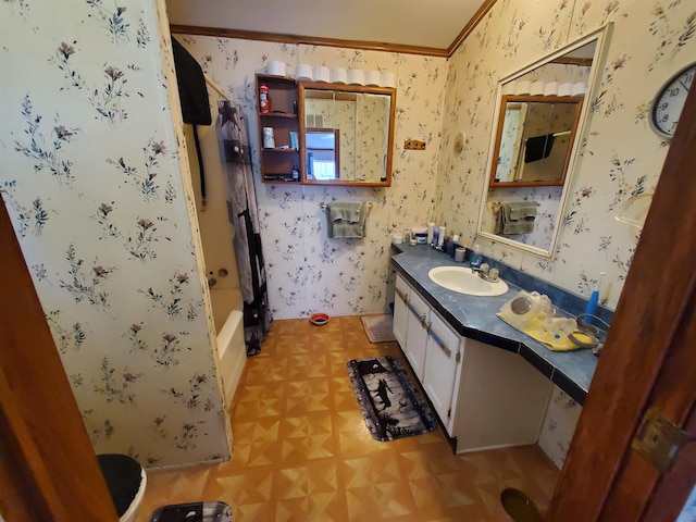 bathroom featuring wallpapered walls, shower / bath combo with shower curtain, crown molding, and vanity