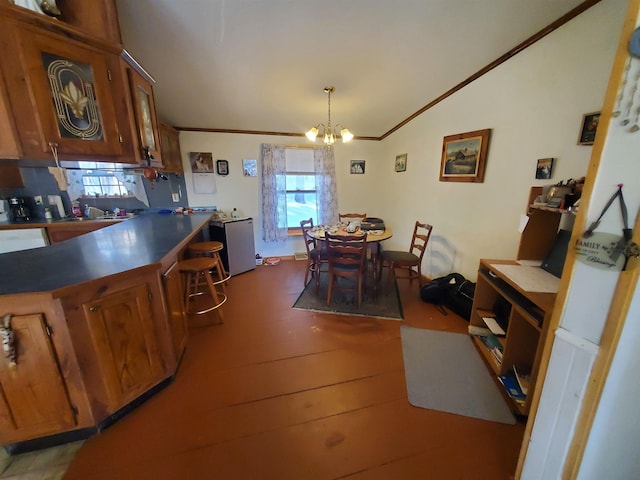 dining room featuring lofted ceiling, wood finished floors, a chandelier, and crown molding