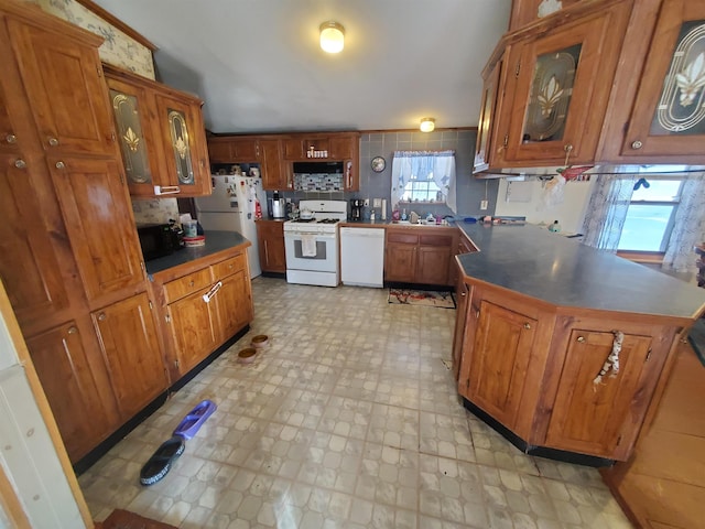 kitchen with a peninsula, white appliances, brown cabinetry, and light floors