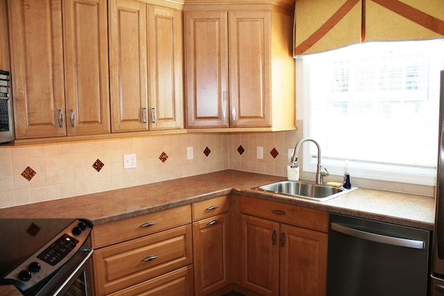 kitchen featuring tasteful backsplash, appliances with stainless steel finishes, brown cabinets, and a sink