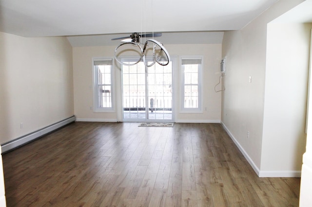 spare room with a notable chandelier, baseboards, baseboard heating, and wood finished floors