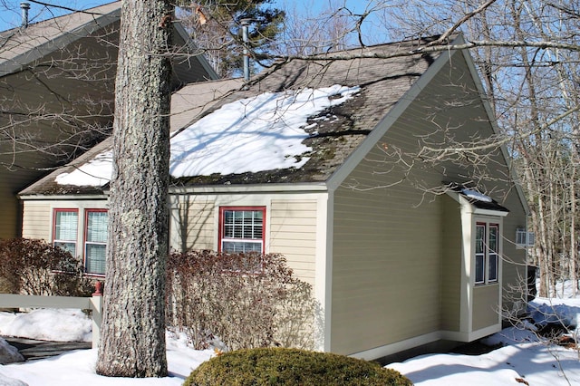 view of snow covered exterior with a shingled roof