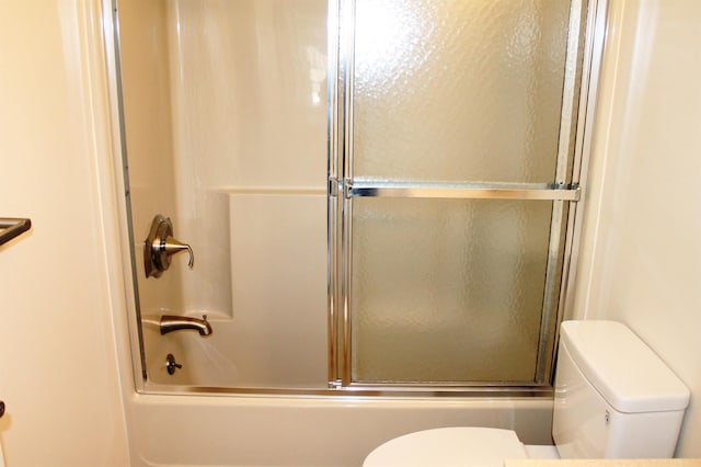 full bathroom with combined bath / shower with glass door and toilet