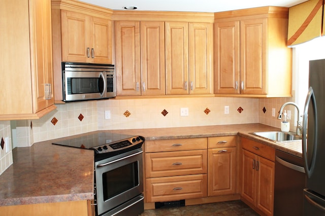 kitchen featuring stainless steel appliances, backsplash, and a sink