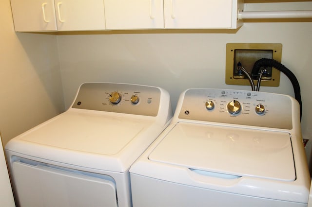 washroom with cabinet space and independent washer and dryer