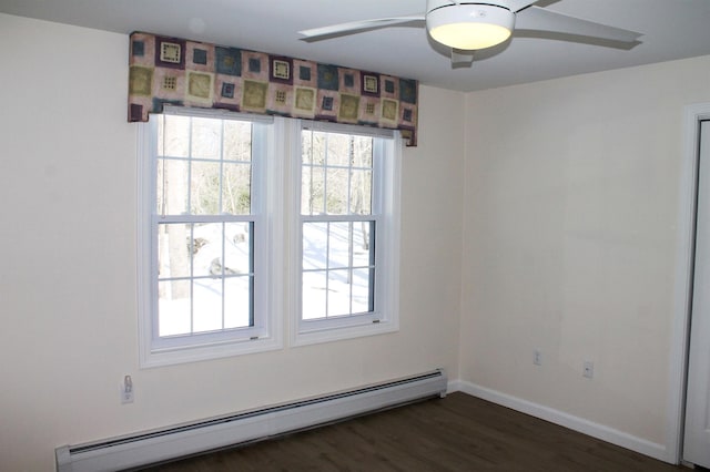 spare room featuring a baseboard radiator, baseboards, dark wood-type flooring, and a ceiling fan