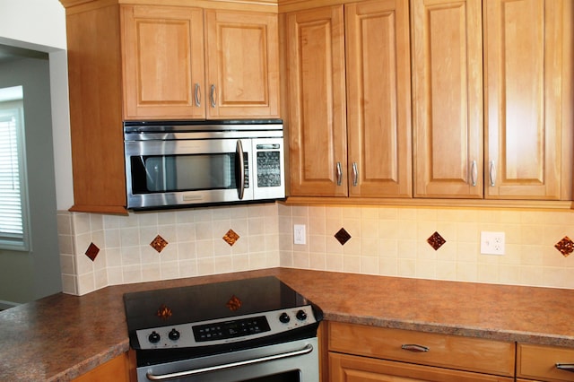 kitchen featuring dark countertops, tasteful backsplash, and appliances with stainless steel finishes