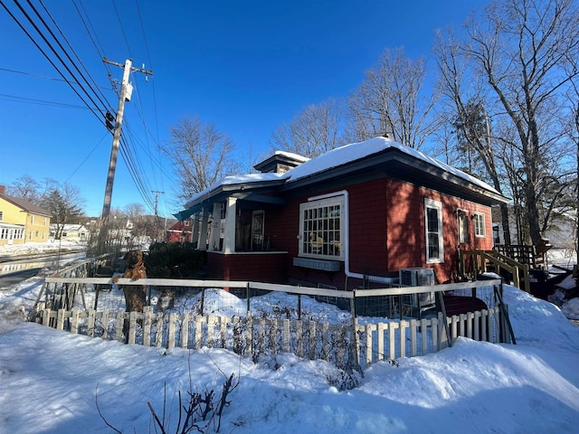 snow covered property with a fenced front yard