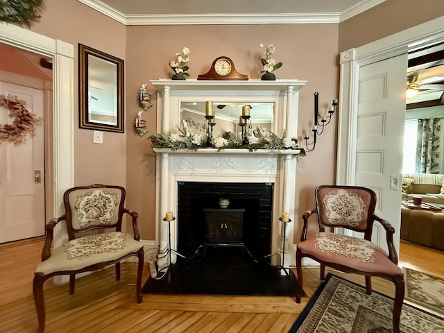 sitting room featuring ornamental molding, wood finished floors, and a ceiling fan