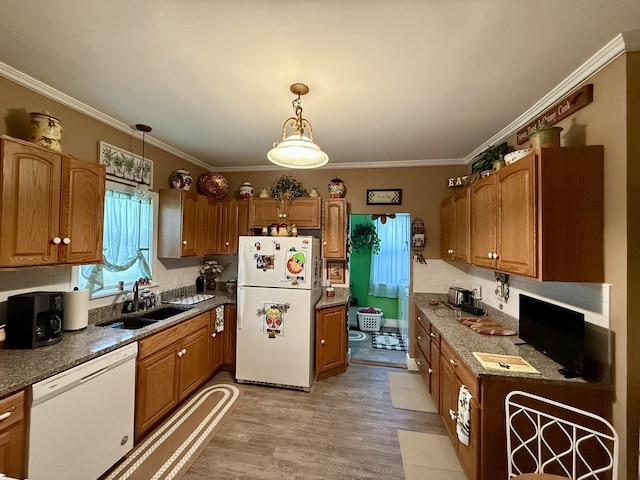 kitchen featuring brown cabinets, light wood-style flooring, ornamental molding, a sink, and white appliances