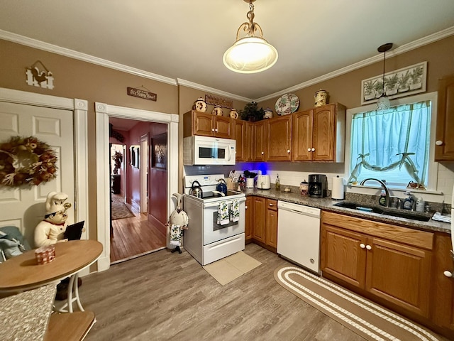 kitchen featuring crown molding, white appliances, a sink, and light wood finished floors