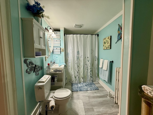 bathroom with visible vents, toilet, ornamental molding, wood finished floors, and curtained shower