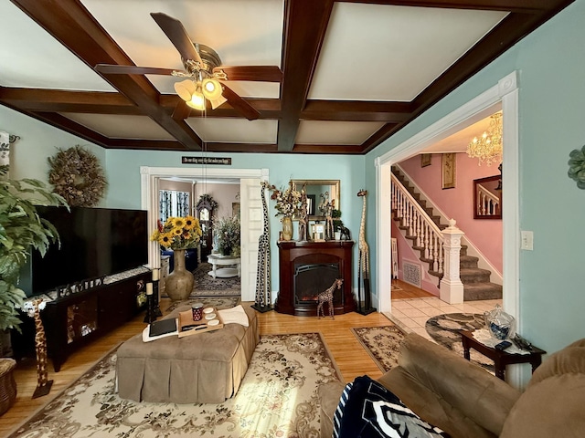 living room with coffered ceiling, wood finished floors, a fireplace, stairway, and beam ceiling