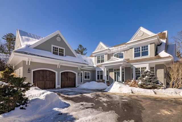 shingle-style home featuring a garage and driveway